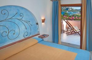 坎尼吉翁卡拉迪法尔科度假酒店的一间卧室设有一张床,享有阳台的景色
