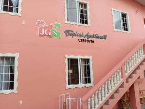 克朗角JGs Tropical Apartments的粉红色的建筑物外墙