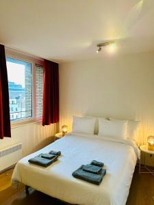 布鲁塞尔Urbanstay Suites Grand Place Luxury Apartment的一间卧室配有一张床,上面有两条毛巾