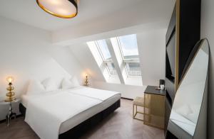 维也纳elaya hotel vienna city center的卧室设有白色的床和大窗户