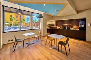 卡波圣卢卡斯City Express Suites by Marriott Cabo San Lucas的带2张桌子和椅子的房间以及厨房