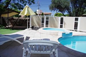 门多萨特拉贝拉公寓的庭院设有游泳池、椅子和桌子