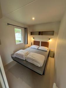 杜柏Camping De la vallée的一间卧室设有一张大床和窗户