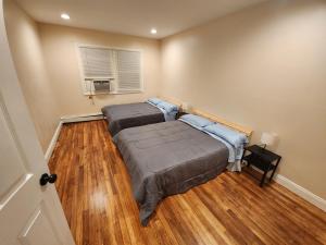 泽西市Stylish 3 bed, minutes to NYC!的配有2张床的木地板客房