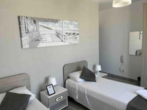 姆西达F12-1 Room 2 single beds shared bathroom in shared Flat的卧室配有两张床,墙上挂着一幅画