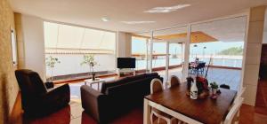 帕莱索海滩Bright 4 bedroom Villa, Pool and Tennis court的客厅配有桌椅和电视。