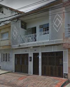 布卡拉曼加Casa San Alonso的一座带两个车库门和阳台的建筑