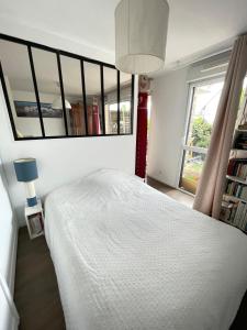 普洛埃默Studio récent Cosy - Ploemeur的卧室配有白色的床和大镜子