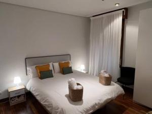 毕尔巴鄂City Central By Sleep In Bilbao的一间卧室配有一张带两盏灯的大型白色床。