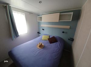 莱马特Ma pause Charentaise的一间卧室配有一张蓝色的床,上面有帽子