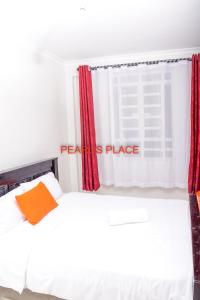 MeruPearl's Place的卧室配有白色的床和红色窗帘