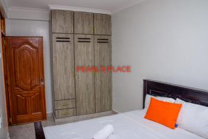 MeruPearl's Place的一间卧室配有一张床和一个木制衣柜