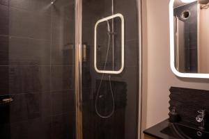 圣埃尔布兰Chambre d hôte的浴室里设有玻璃门淋浴