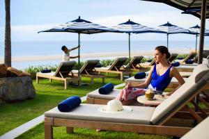 华欣华欣万豪水疗度假酒店的坐在海滩躺椅上的女人