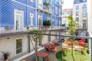 里斯本Haws Lisboa的公寓的阳台拥有蓝色建筑和桌椅。