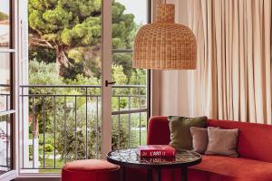 圣特罗佩Hotel Lou Pinet的客厅配有红色的沙发和桌子