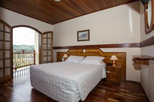 坎波斯杜若尔当莱奥达蒙塔尼亚酒店的一间带大床的卧室和一个阳台