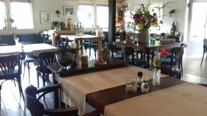 德摩尔Camping de Zwammenberg的餐厅设有桌椅,并种有鲜花