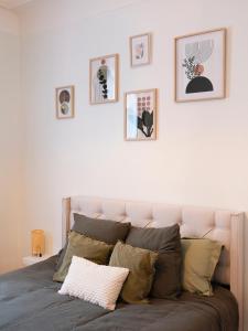 梅斯Le Haut Cloquais - SereniStay的卧室配有一张墙上许多照片的床