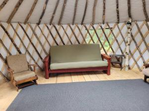 BrownfieldAva Jade Yurt的蒙古包内的一个房间,配有沙发和椅子