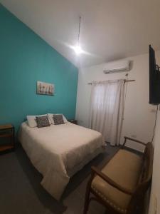 圣地亚哥-德尔埃斯特罗casa familiar confortable的一间卧室配有一张大床和一把椅子