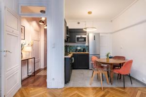 里昂Le Cocon Savoir的厨房以及带桌椅的用餐室。