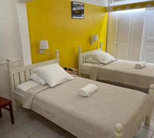 圣安尼乐鲁塔巴斯酒店的黄色墙壁客房的两张床