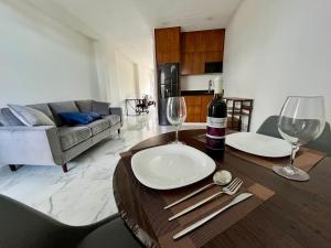 普拉亚卡门Comfort Apartment Gaia - 5 Av.的客厅配有带酒杯的桌子