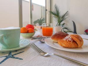 斯菲拉卡瓦洛B&B Una Terrazza sul Golfo di Sferracavallo的一张桌子,早餐包括羊角面包和橙汁