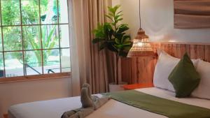 长滩岛Senare Boracay Hotel的一间卧室配有一张带吊灯和窗户的床