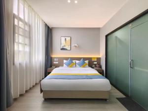 简阳贤丰精品酒店(天府国际机场店）的一间卧室配有蓝色和黄色枕头的床