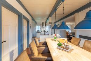 埃默尔斯比尔－霍斯比尔Juwel am Deich的厨房以及带木桌和蓝色吊灯的用餐室。