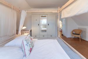 埃默尔斯比尔－霍斯比尔Juwel am Deich的一间卧室配有一张带天蓬的大型白色床