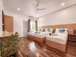 MahibadhooRaalhu Fonu Maldives的一间带两张床和一张沙发的客厅
