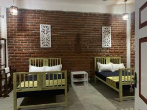 MadamSky 14 Resort Yala的一间卧室设有两张床和砖墙