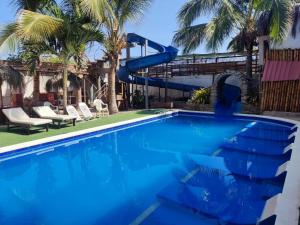 曼克拉MAU Suite&Apartment的蓝色游泳池,带水滑梯