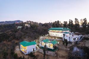 穆克缇斯瓦Shree Parijat Resort At Mukteshwar Hill Station with Himalayan View的享有带绿色屋顶的大房子的空中景致