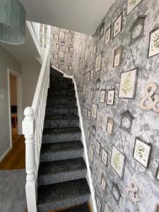 贝尔法斯特Connswater Town House Belfast的楼梯,墙上挂着照片