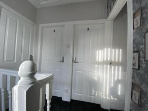 贝尔法斯特Connswater Town House Belfast的一间设有门和桌子的白色客房