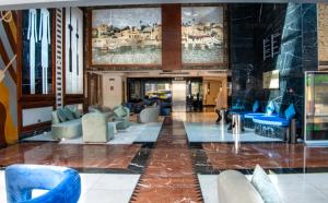 迪拜Social Hotel formerly Byblos的大堂设有蓝色椅子和壁画