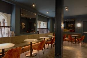博洛尼亚Hotel Brun的餐厅设有桌椅和沙发。