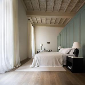 罗马Parisii Bocca di Leone 88的卧室设有一张白色大床和两个窗户。