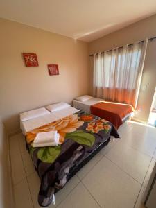 戈亚斯州上帕莱索Mirante do Morro的客房设有两张床和窗户。