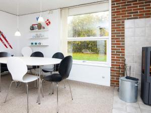 海默特6 person holiday home in Hemmet的一间带桌椅和窗户的用餐室