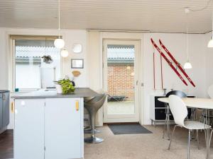 海默特6 person holiday home in Hemmet的厨房配有白色橱柜和桌椅