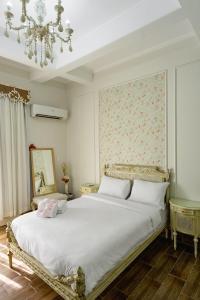 开罗El Otel The Hotel的卧室配有一张带吊灯的大型白色床。