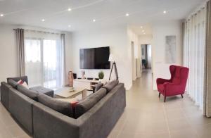 蓬他达维托亚Casa Panorama Sol的客厅设有大沙发和红色椅子