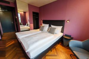 因戈尔施塔特瑞姆瑞齐酒店的紫色墙壁的房间里一张大床