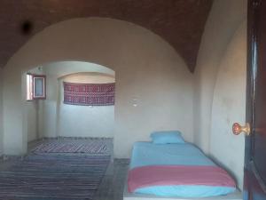 锡瓦Oum House的一间小房间的卧室,配有一张床铺