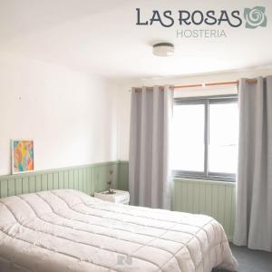 埃斯克尔Hostería Las Rosas的一间卧室设有一张大床和一个窗户。